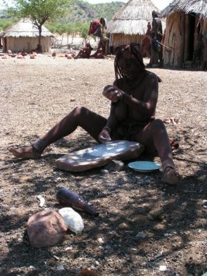 トウモロコシをすり潰すヒンバの女性
